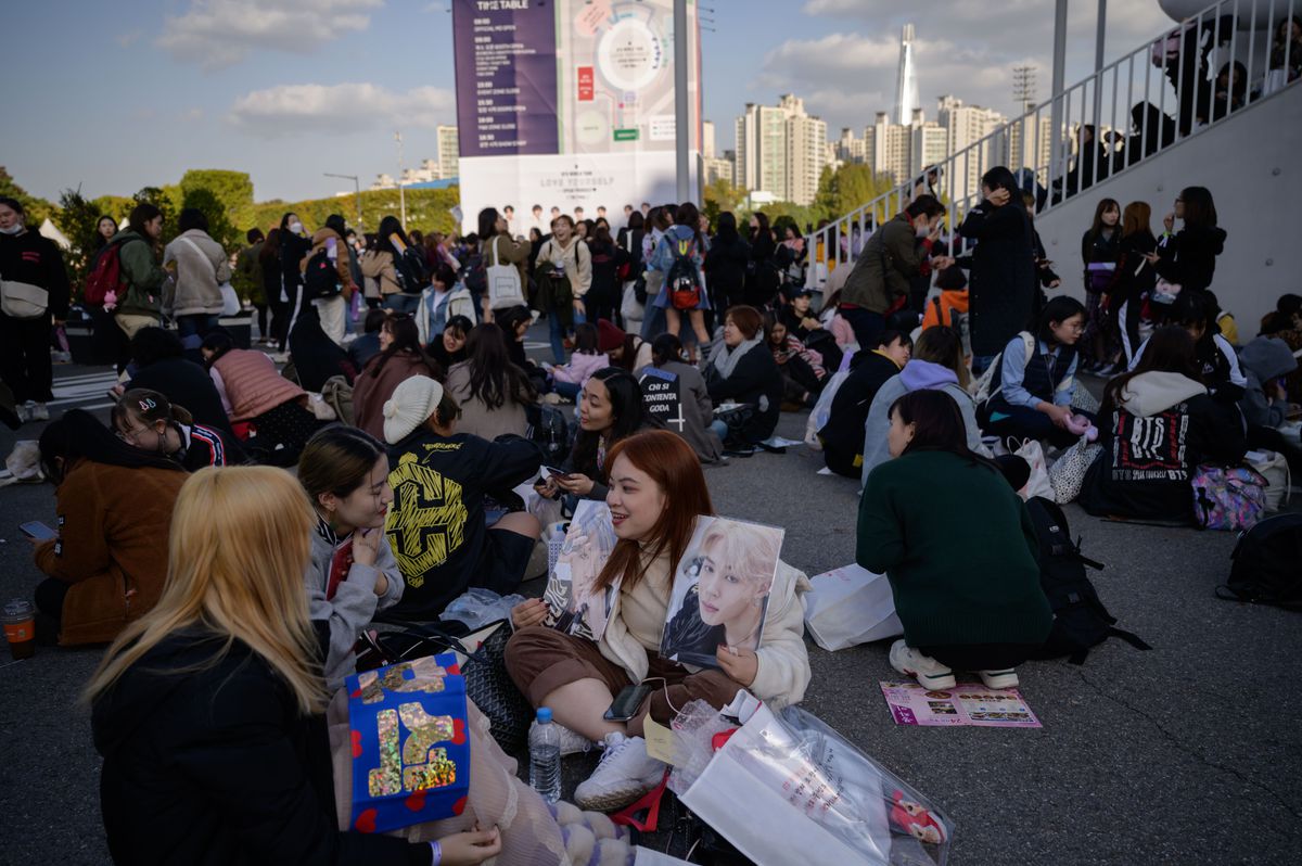 Fans sit outside the Olympic stadium in Seoul waiting for BTS’s final concert of their 2019 world tour.