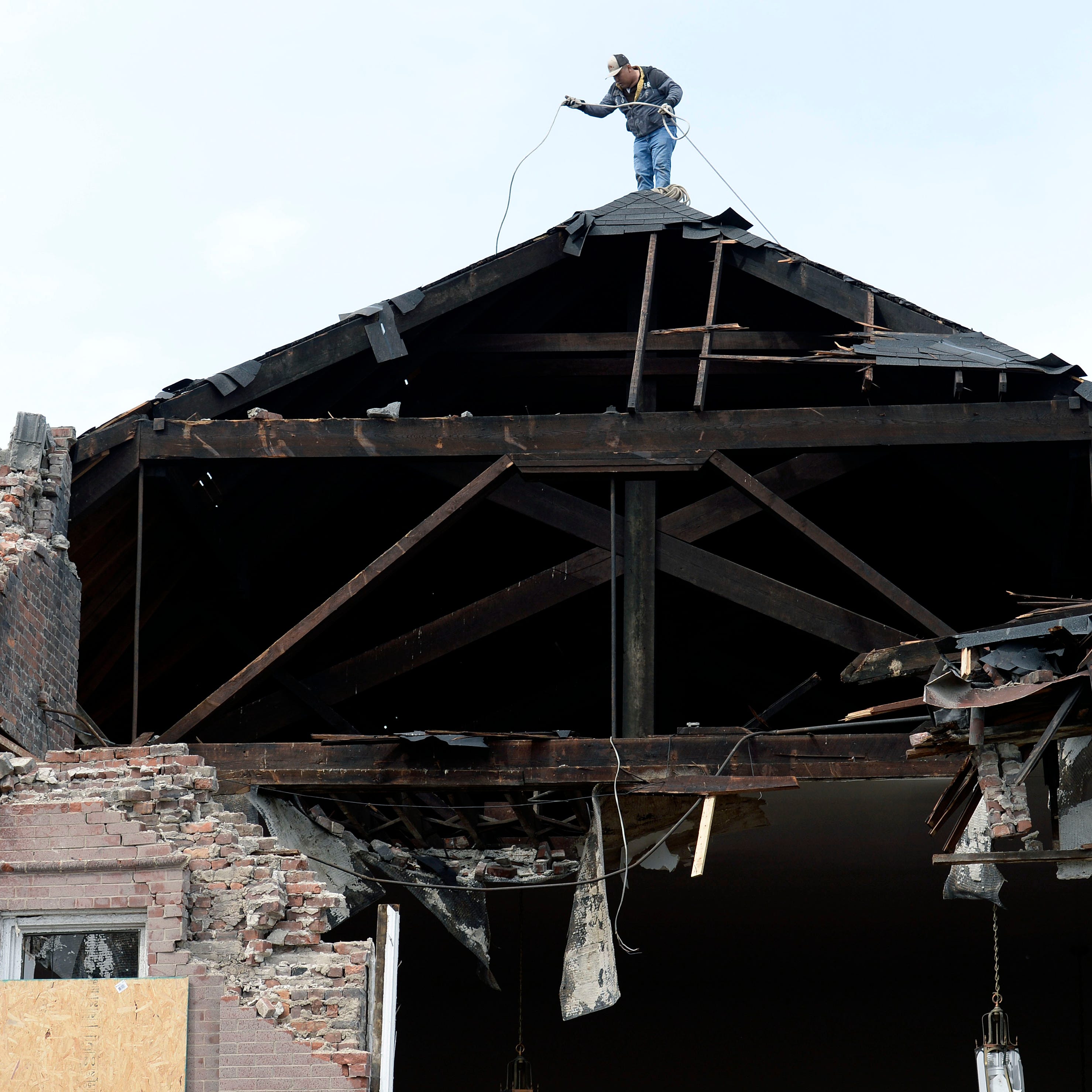 Artemio Salgado puts rope across the top of the tornado damage Hopewell Baptist Church before covering the opening with a tarp on Wednesday, March 4, 2020, in North Nashville, Tenn. 