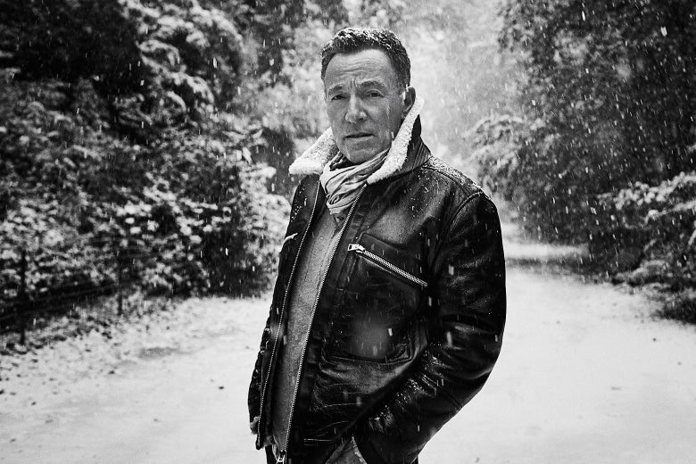 A black-and-white photo of Bruce Springsteen standing in a snowy woods.