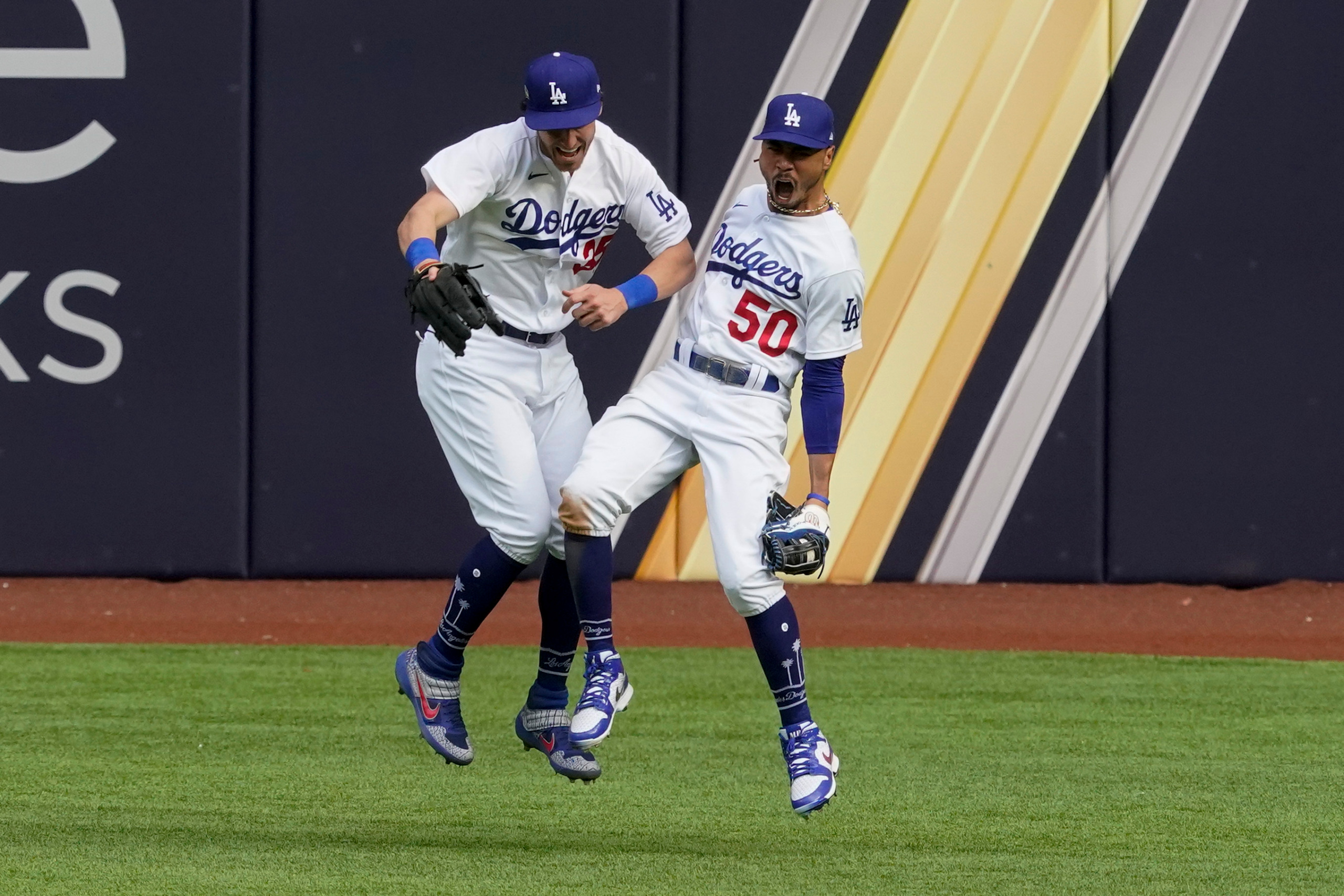 Los Angeles Dodgers right fielder Mookie Betts celebrates with center fielder Cody Bellinger after robbing Atlanta Braves' Marcell Ozuna of a home during the fifth inning in Game 6 of a baseball National League Championship Series Saturday, Oct. 17, 2020, in Arlington, Texas. (AP Photo/Tony Gutierrez)